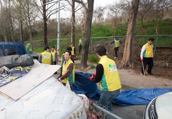 도로변에 쌓인 대형 생활 쓰레기를 치우고 있는 신천지 자원 봉사단