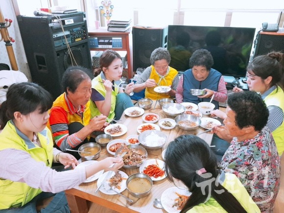 호산대 학생들이 봉사활동 후 마을 어르신들과 식사를 하고 있다. 사진제공=호산대학교