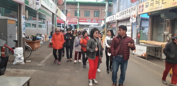 음성 무극전통 시장을 둘러보고 있는 대전 반딧불 야학교 김진중교장선생님과 학생들