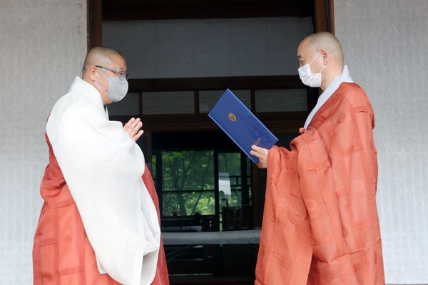 마곡사 주지로 당선된 원경스님(좌측)이 중앙선거관리위원장 세영 스님으로부터 당선증을 교부받고 있다.