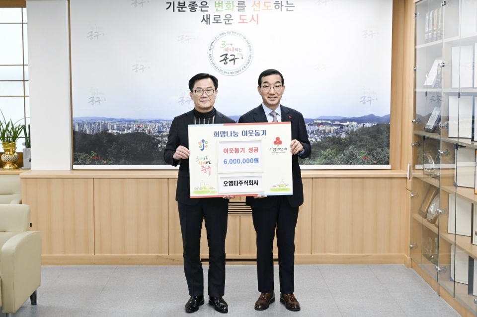 오엠티그룹 오명탁 회장(왼쪽)이 김광신 대전중구청장(오른쪽)에게 이웃돕기 성금 600만원을 전달하고 있다.