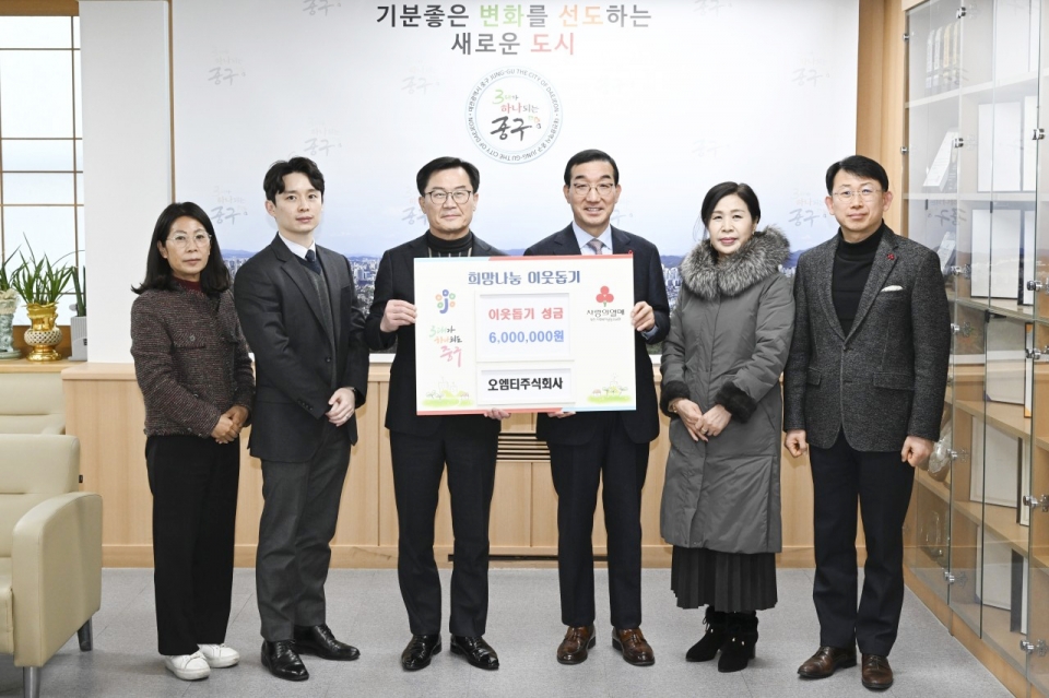 오엠티그룹 오명탁 회장이 김광신 대전중구청장에게 이웃돕기 성금 600만원을 전달하고 기념사진을 찍고있다.