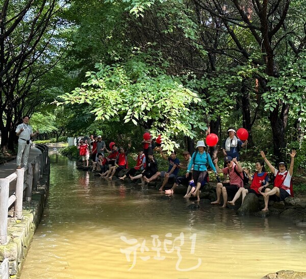 김도남 어싱스쿨 서울숲 맨발걷기 도중 시냇물에 발을 담그고 쉬는 참가자들