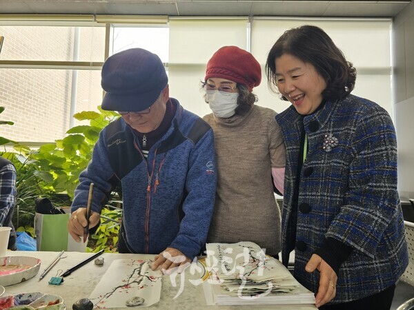 효령타운 정경남 본부장(오른쪽)이 입춘방을 쓰시는 문인화반 회원을 보면서 함박웃음을 짓고 있다.