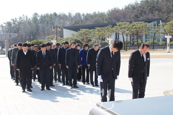 박균택 예비후보가 경선 승리 이후 첫 공식일정으로 국립5‧18민주묘지를 찾아 5‧18민중항쟁추모탑 앞에서 분향 후 영령들에게 참배하고 있다. 박균택 예비후보가 김범태 소장과 함께 묵념을 하고, 그 뒤로 김명수 광산구의원, 송병태 전 광산구청장, 윤봉근 전 광주시의장, 배홍석 전 광산구의장, 이영순 전 광산구의장, 김미영 전 광산구의원, 고광우 광주 대동고 광산지역 동문회장 등이 함께하고 있다.