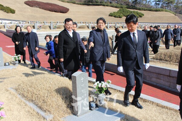 박균택 예비후보가 국립5‧18민주묘지를 찾아 윤봉근 전 광주시의장의 안내로 광산구 송정 출신인 나병식 열사dml 묘소로 들어서고 있다. 그 뒤에는 김명수 광산구의원, 김미영 전 광산구의원, 배홍석 전 광산구의장, 이영순 전 광산구의장과 지지자들의 모습이 보인다.