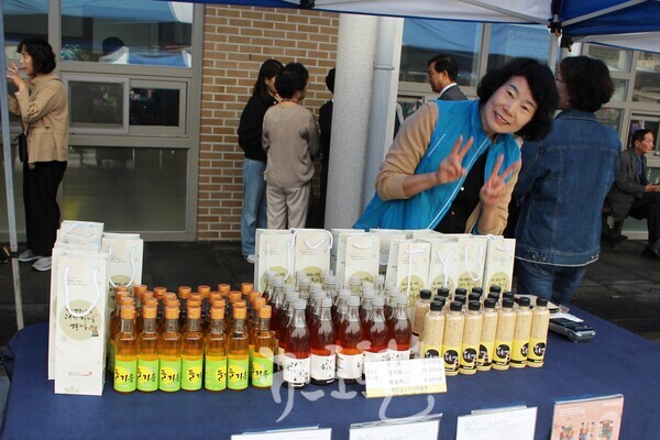 남구시니어클럽 어르신이 효령노인복지타운 노인의 날 기념 ‘꿈꾸는 노년, 언제나 청춘’ 행사에서 참기름, 들기름 등을 판매하던 중 포즈를 취하고 있다.