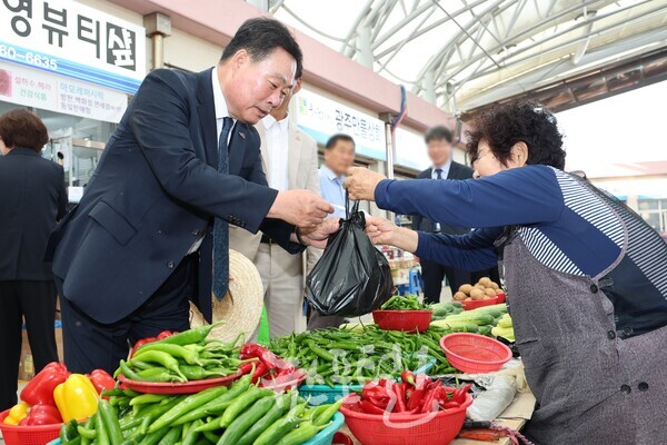 김산 군수가 4일 민선 8기 3주년 기념식에 앞서 아침 일찍 무안 전통시장에서 상인들을 격려하며 장을 보고 있다. (사진 제공 : 무안군)