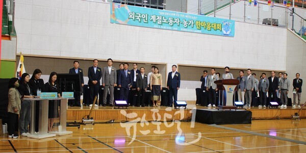 무안군 제2회 계절노동자•농가 한마음대회 국기에 대한 경례 직전 모습. 김산 군수와 바니 께오싸이야봉 라오스 고용국 부국장, 강행원 외국인계절근로자 무안군연합회장, 이호성 무안군의회의장, 나광국 전라남도의회의원, 박문재 무안군 번영회장 등 내빈과 (특이하게) 네 명의 사회자가 함께하고 있다.