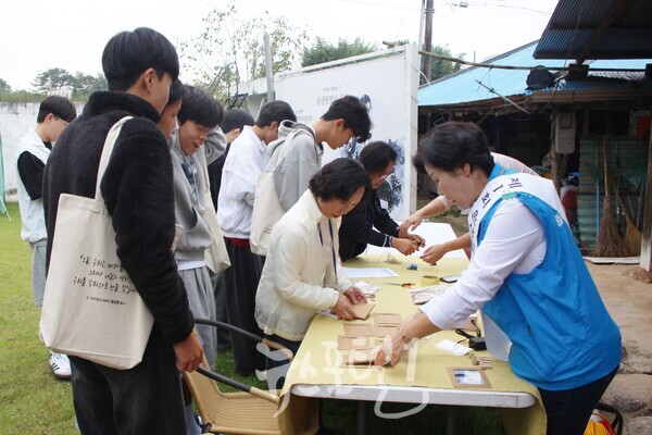 「제1회 윤상원 백일장대회」 참가 학생들이 작품을 제출하기 위해 열사의 생가에 들어 방문 확인을 받고 있다. 대회 측은 제출 원고에 생각 방문 확인을 받도록 했다.