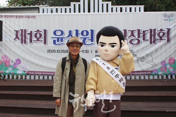 윤상원 열사를 향한 ‘그대 살아 있다면’이란 시를 쓴 김수(본명 김형수, 광주평화포럼 대표이사) 심사위원이 「제1회 윤상원 백일장대회」 시작 전 청년 윤상원과 기념 촬영하고 있다.