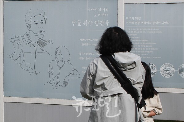 「제1회 윤상원 백일장대회」에 참가한 진만초 어린이와 엄마가 함께 님을 위한 행진곡 탄생 배경을 읽고 있다.