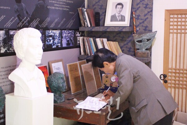 「제1회 윤상원 백일장대회」의 김용하 심사위원장이 윤상원 열사 생가를 방문해 방명록에 서명하고 있다.