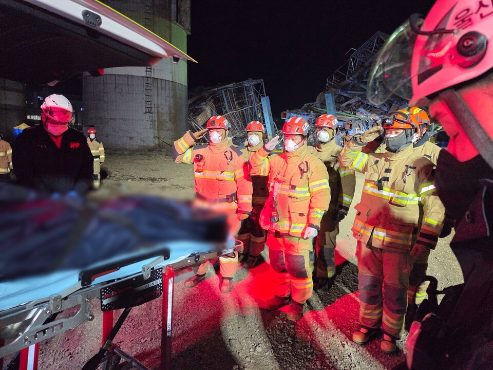 ▲ 11일 밤 10시 14분경, 울산 남구 화력발전소 보일러 타워 붕괴 현장에서 구조대원들이 매몰된 60대 남성의 시신을 수습한 뒤 엄숙히 경례를 올리고 있다.  사진=울산소방본부