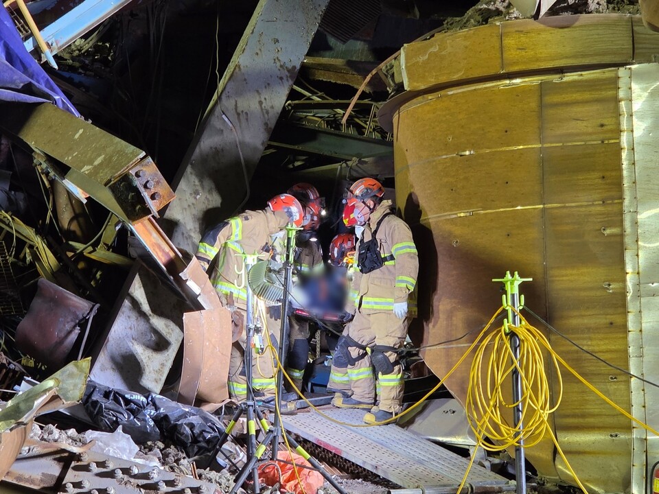 ▲ 11일 울산 남구 화력발전소 보일러 타워 붕괴 현장에서 구조대원들이 잔해 속을 비집고 들어가 매몰자를 찾기 위해 심야 수색작업을 벌이고 있다.   사진=울산소방본부